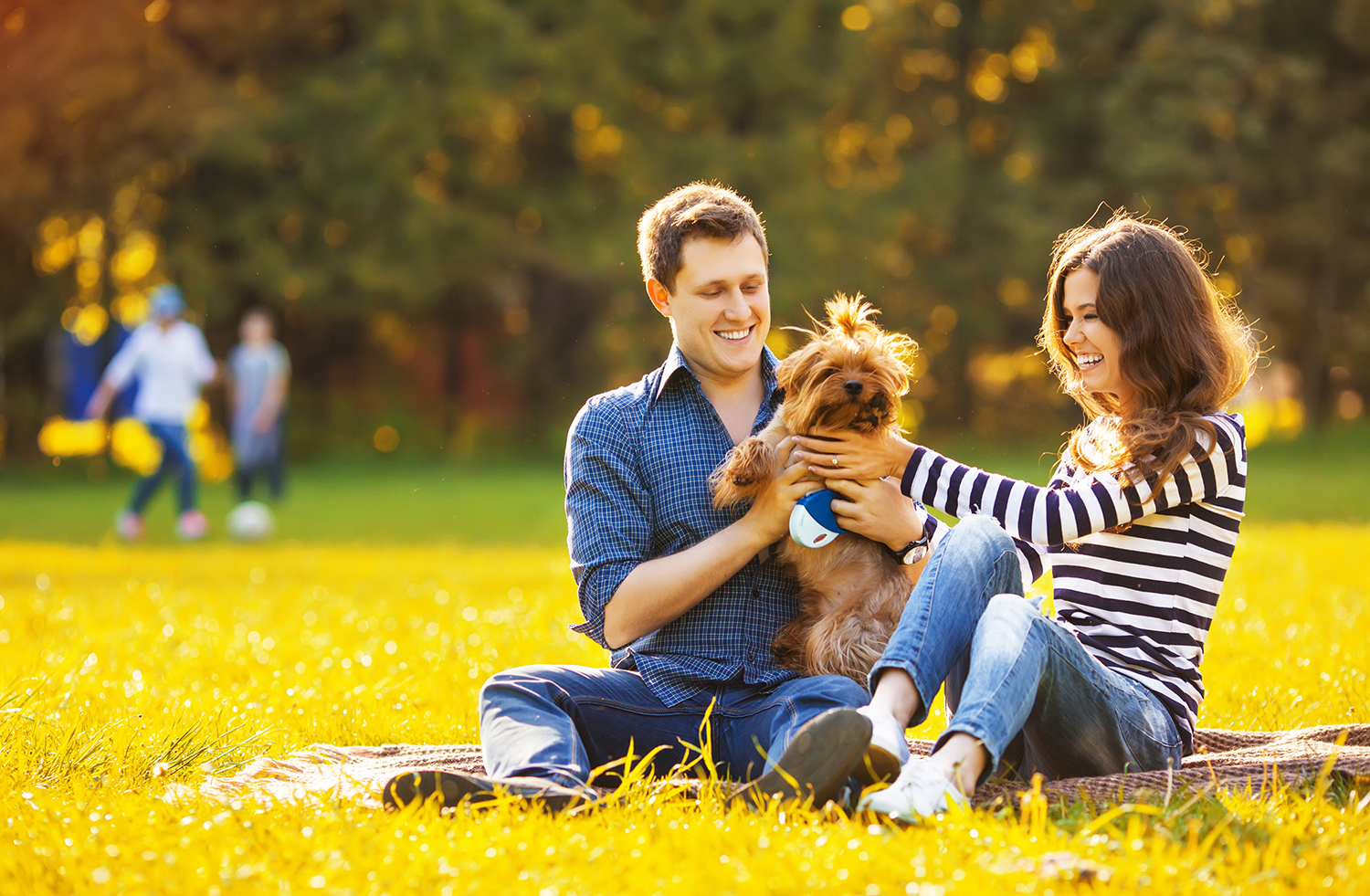 Happy family of two resting at a picnic in the park w