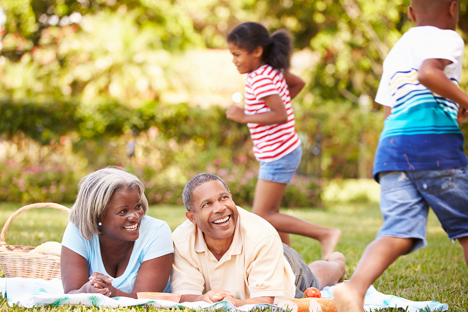 Grandparents And Grandchildren Having Picnic In Garden